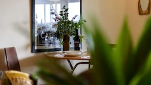 A dining area with a table, chairs, a potted plant, and a poster on the wall. - Tranquil Vacation Rental with Amazing Lake Views and Hiking Trails in Daylesford, Victoria (Daylesford)