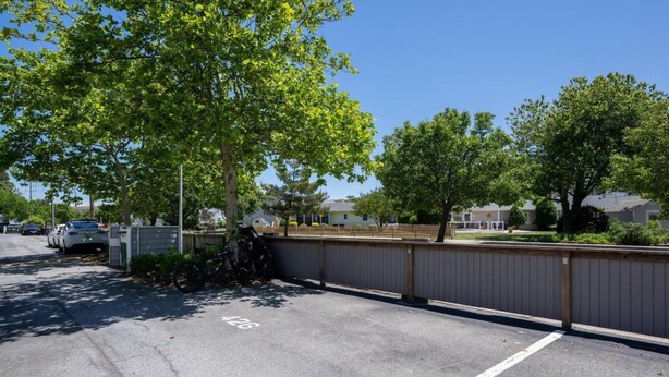 A parking lot with marked spaces, a bicycle, and a fence. - East of the Sun - 39916 E Sun Dr #426 (Fenwick Island)