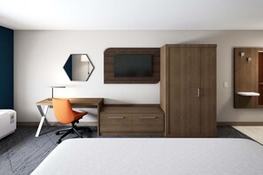 Ein modernes Hotelzimmer mit Bett, Schreibtisch mit Stuhl, Kleiderschrank, Spiegel und Fernseher.