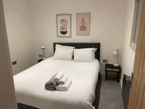 A hotel room with a bed, two bedside tables, and a wall-mounted artwork. - 3 Nottingham Apts + Castle Views & City Centre (Nottingham)