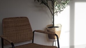 A wicker chair with a metal frame, a potted plant, and a framed quote on the wall. - 3 Nottingham Apts + Castle Views & City Centre (Nottingham)