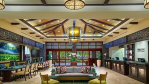 A spacious lobby with a reception desk, seating area, and a large window providing a view of the outdoors. - Princeville One Bedroom Villa Resort w/ Amenities (Princeville)