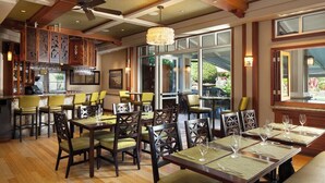 A restaurant with wooden flooring, multiple tables and chairs, and a bar area. - Princeville One Bedroom Villa Resort w/ Amenities (Princeville)