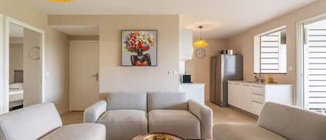 A modern living room with a sofa set, a coffee table, and a painting on the wall.