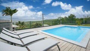 Une piscine dotée de chaises longues et offrant une vue sur le paysage.