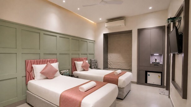 A hotel room with two beds, a minibar, and a television. - The Bay Suites - Salt Lake AE Market (Bidhannagar)
