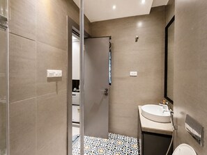 Une salle de bain moderne avec une douche, un lavabo et un miroir.