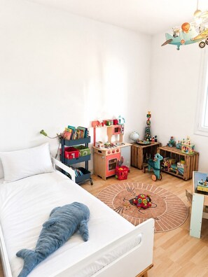 Ein Kinderzimmer mit Bett, Spielzeug und einem Globus.