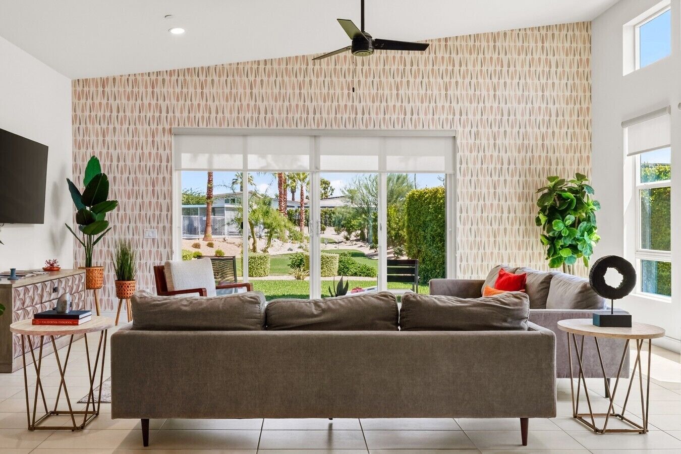 A modern living room with a sectional sofa, a coffee table, and a TV mounted on the wall.