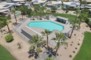 A residential area with a swimming pool surrounded by palm trees and modern houses. - 4BR| Pool | Firepit| Patios, Mtn Views| Next to Tennis Garden & Golf Resort (Indian Wells)