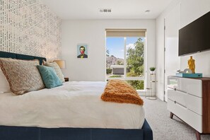 A bedroom with a bed, a TV, a window, and a view of the outdoors. - Chic Indian Wells Pool, 4 BD-Next to Tennis Garden (Indian Wells)