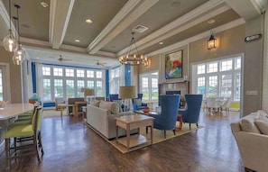 A spacious living area with a fireplace, a dining table, and a kitchen in the background. - Millville by the Sea- shuttle access Bethany beach (Millville)