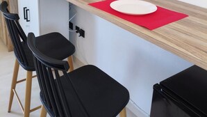 A modern kitchenette with a wooden countertop, two bar stools, a small refrigerator, and a flat-screen TV mounted on the wall. - Seaview Apartment Galissas, Blue Lagoon Complex A9 (Galissas)