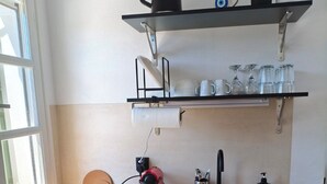 A kitchen with a wooden countertop, a sink, a kettle, a coffee maker, and shelves above holding cups and glasses. - Seaview Apartment Galissas, Blue Lagoon Complex A9 (Galissas)