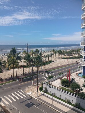Blick auf einen Strand mit Zebrastreifen und Palmen.