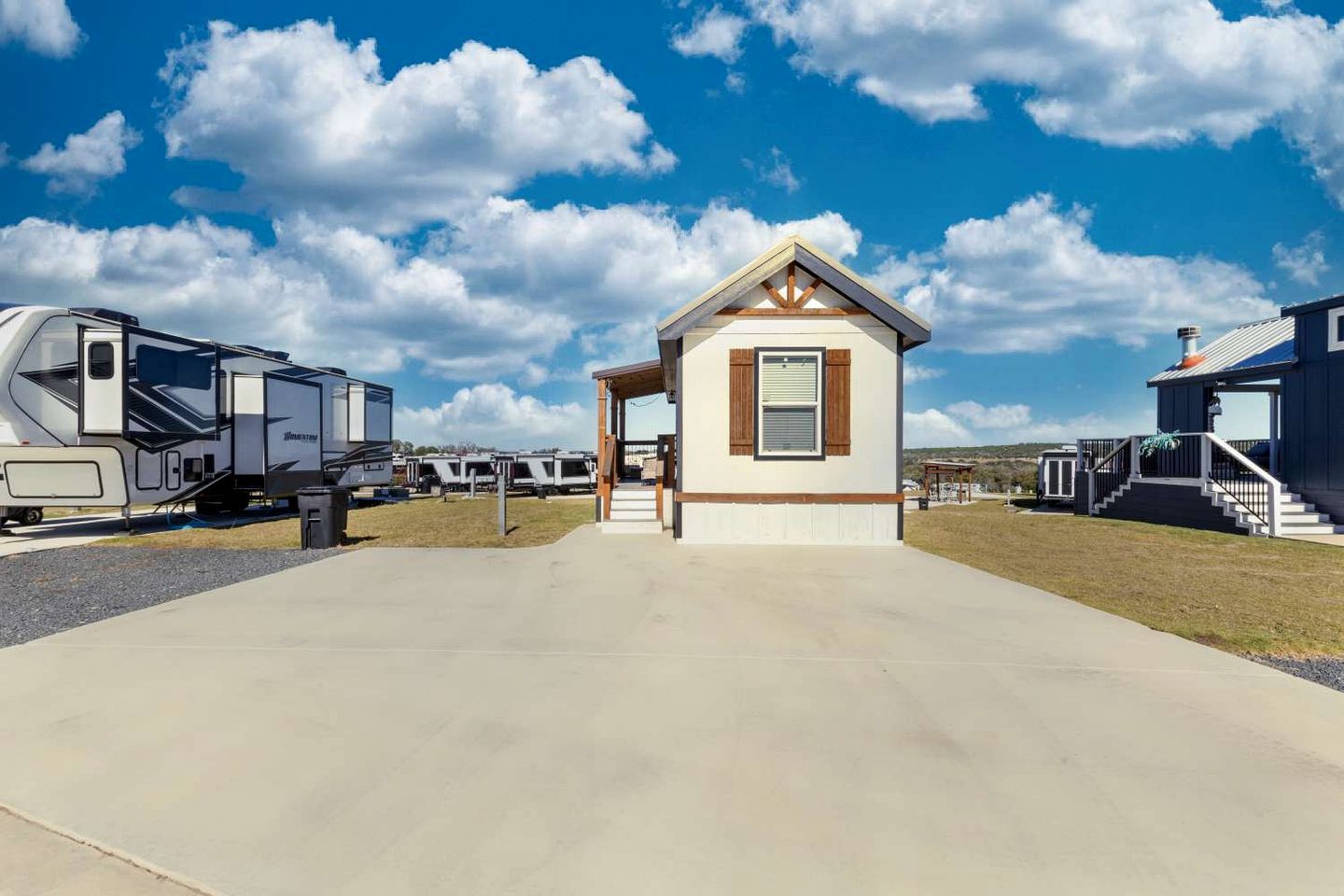 A caravan park with a central building, paved walkways, and multiple caravans.