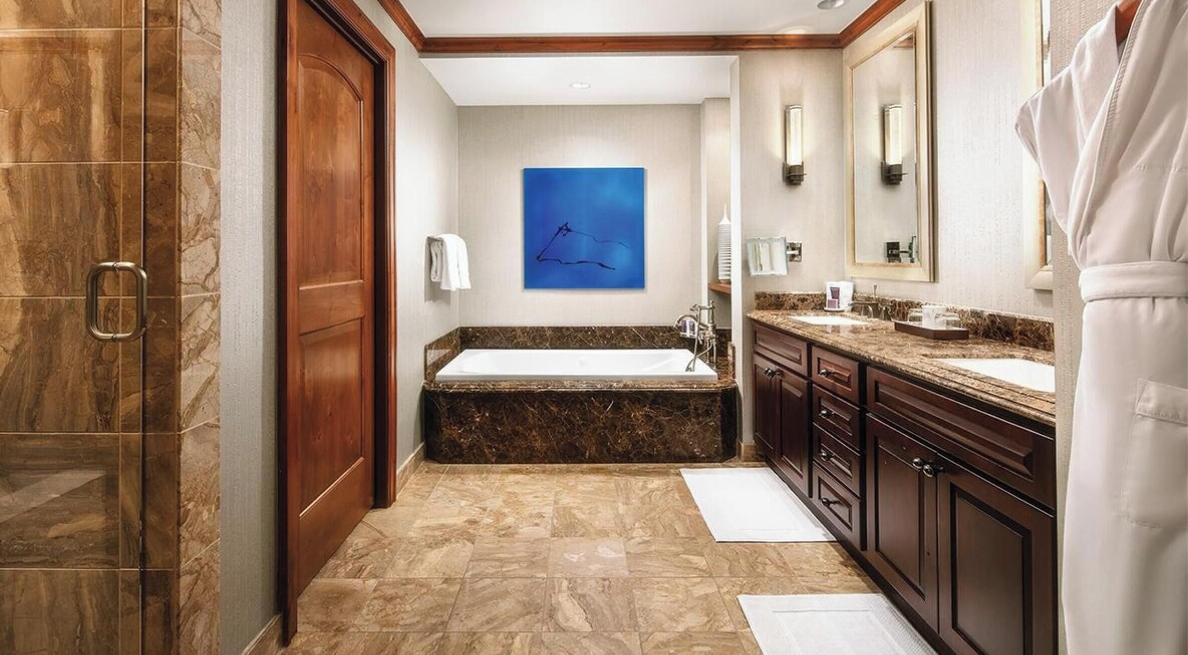 A bathroom with a bathtub, a sink, and a large mirror.
