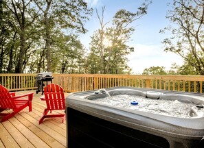 A hot tub on a wooden deck with two red Adirondack chairs, surrounded by trees. - Stunning Dome with Barbecue and Hot-tub in Capon Bridge, West Virginia (Capon Bridge)