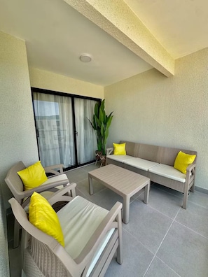 A balcony with a sofa set, chairs, and a table. - Modern Stay / FREE Airport Pickup & Beach Shuttle (Punta Cana)