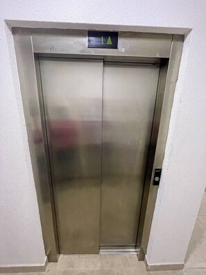 Ein geschlossener Aufzug mit einer digitalen Anzeige darüber.