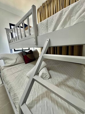 A bunk bed with a white frame and quilted bedding. - Modern Stay / FREE Airport Pickup & Beach Shuttle (Punta Cana)