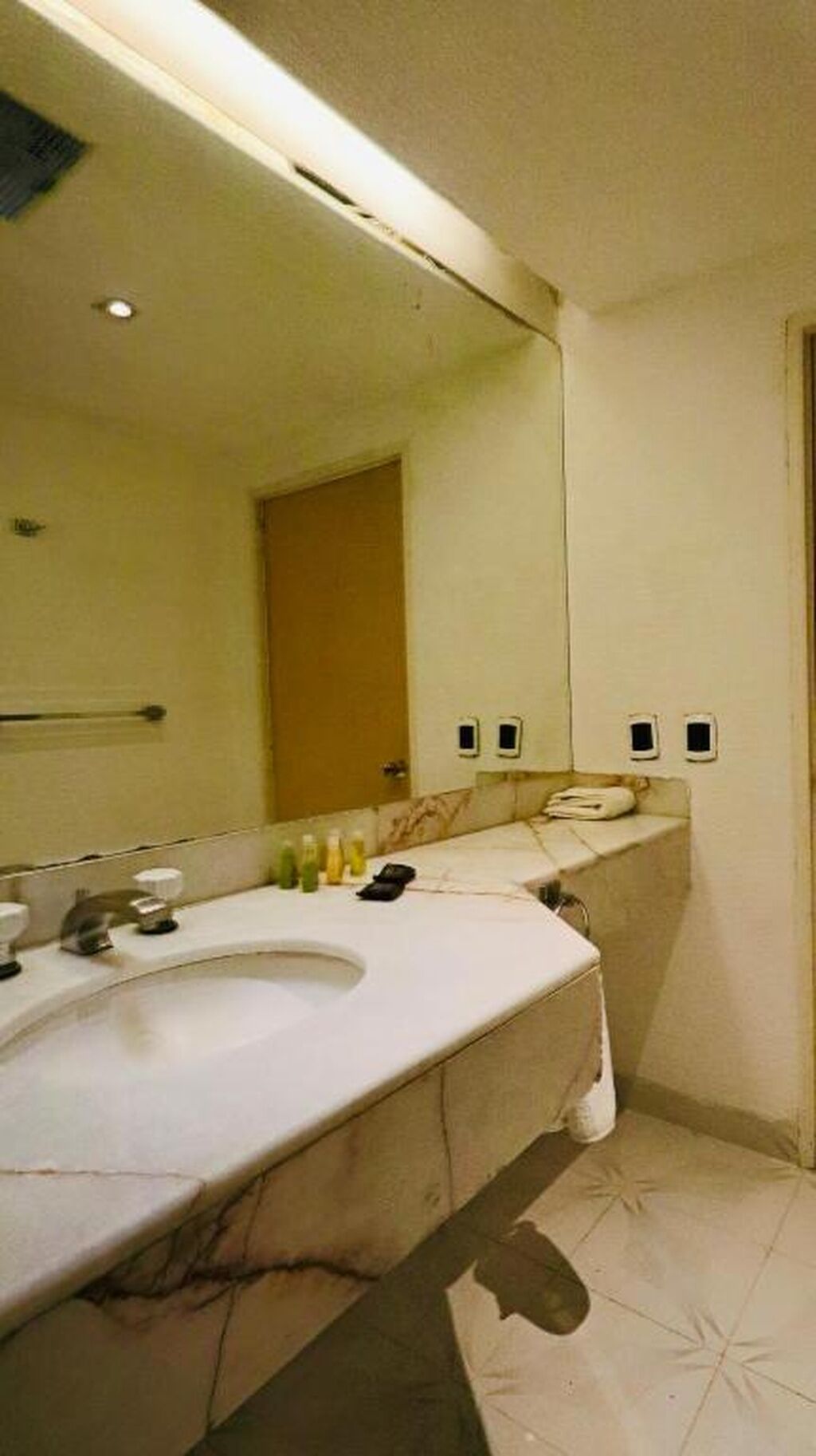 Une salle de bain équipée d’un lavabo, d’un miroir et d’un porte-serviettes.