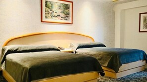 Una cama doble con cabecera de madera, dos almohadas y una manta azul.