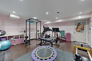 Ein Heimfitnessraum mit Klimmzugstange, Gewichtbank und Trainingsbällen.