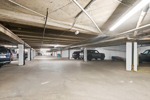 A multi-level parking garage with concrete pillars, overhead lighting, and several parked vehicles. - Vail Couple's Retreat:  Ski & Golf, Near Village (Vail)
