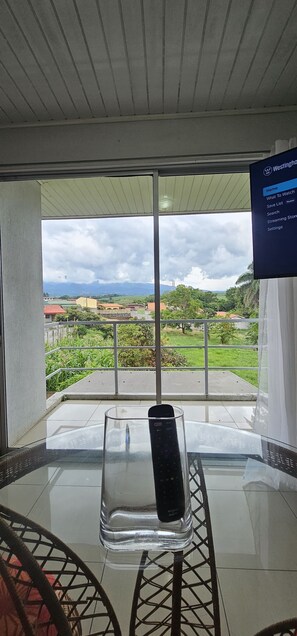 Un balcón con vistas despejadas a un paisaje verde y montañas a lo lejos.