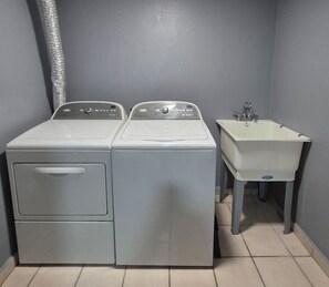Une buanderie équipée de deux machines à laver et d’un évier.