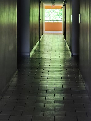 Un couloir au sol décoré de motifs menant à une sortie.
