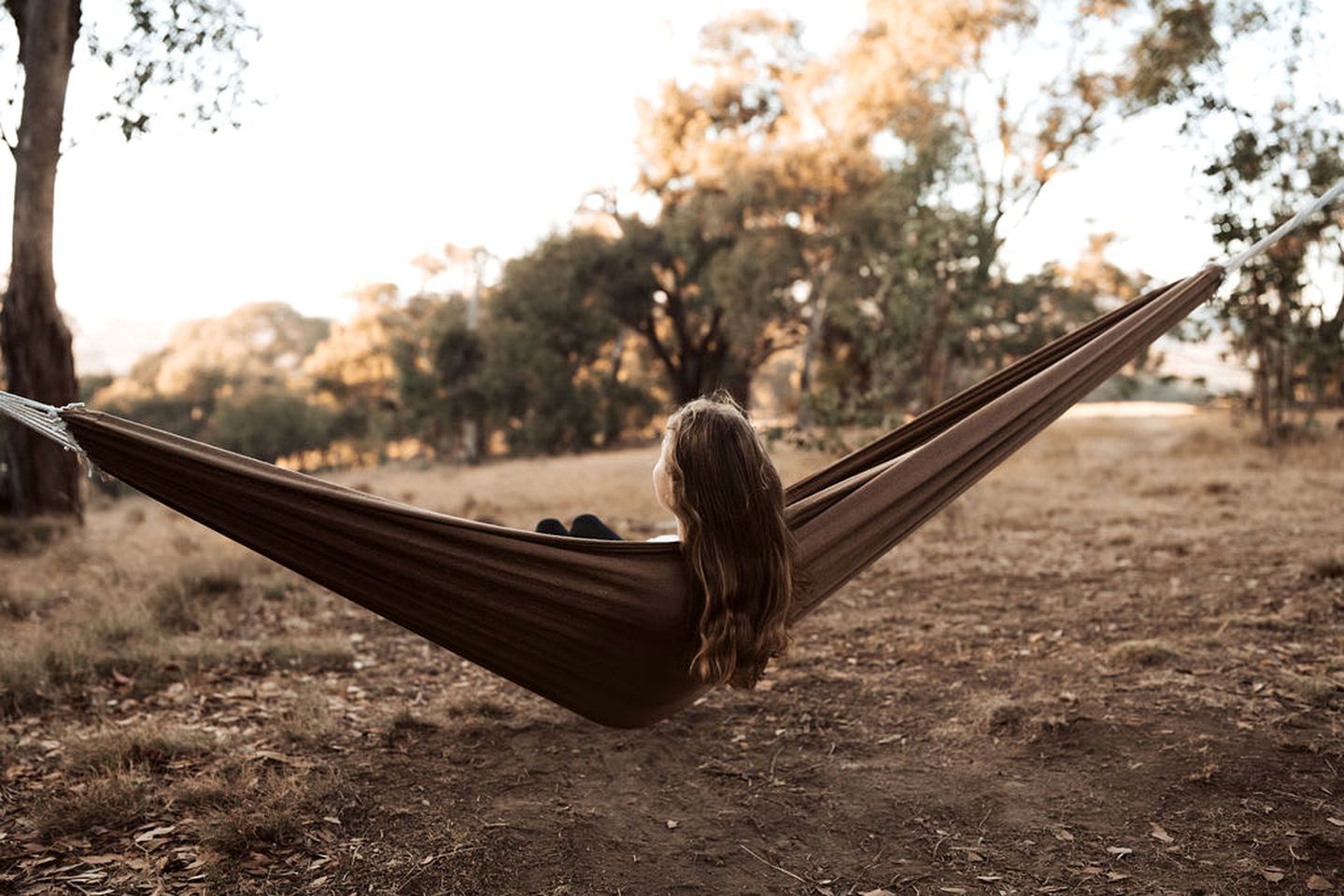 A hammock in a natural setting with trees in the background.