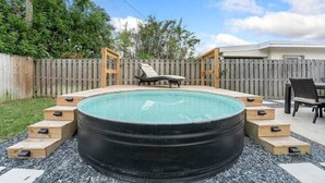 A hot tub with wooden steps leading to it, surrounded by a wooden fence and a grassy area. - Ocean Breeze Cottage: Private Oasis Near Boynton Beach & Delray Beach. (Boynton Beach)