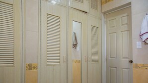 A row of wooden wardrobe doors with louvered tops, a mirror, and a towel hanging on the right. - Beautiful suite for up to 5 people, with a pool and private parking. (Mérida)