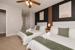 A hotel room with two beds, a ceiling fan, and artwork on the walls. - Stylish 2BR in Tempe | Near ASU w/ Pools & Gym (Tempe)