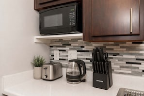A kitchen with a microwave, toaster, coffee maker, and a knife block on the counter. - Stylish 2BR in Tempe | Near ASU w/ Pools & Gym (Tempe)