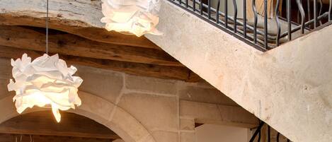 A staircase with a wrought iron railing leading to a balcony.