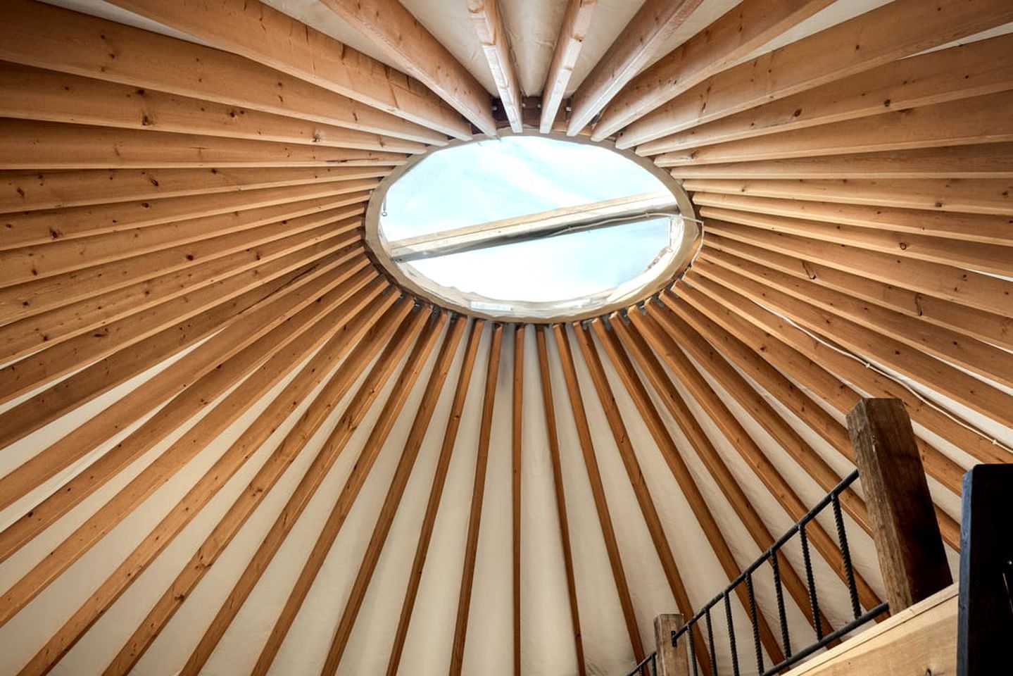 A circular wooden ceiling structure with a skylight.