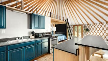 Une cuisine moderne avec des meubles bleus, un four à micro-ondes et un évier.