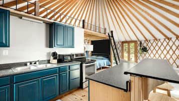 A compact kitchen with a sink, cabinets, and a microwave.