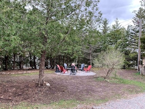 An outdoor seating area with Adirondack chairs arranged around a fire pit.