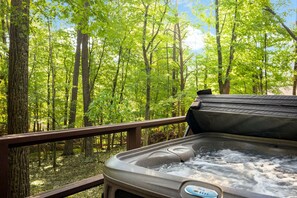 A hot tub on a deck with a forest view. - Incredible Cabin with Hot-tub and Barbecue in Hedgesville, West Virginia (Hedgesville)