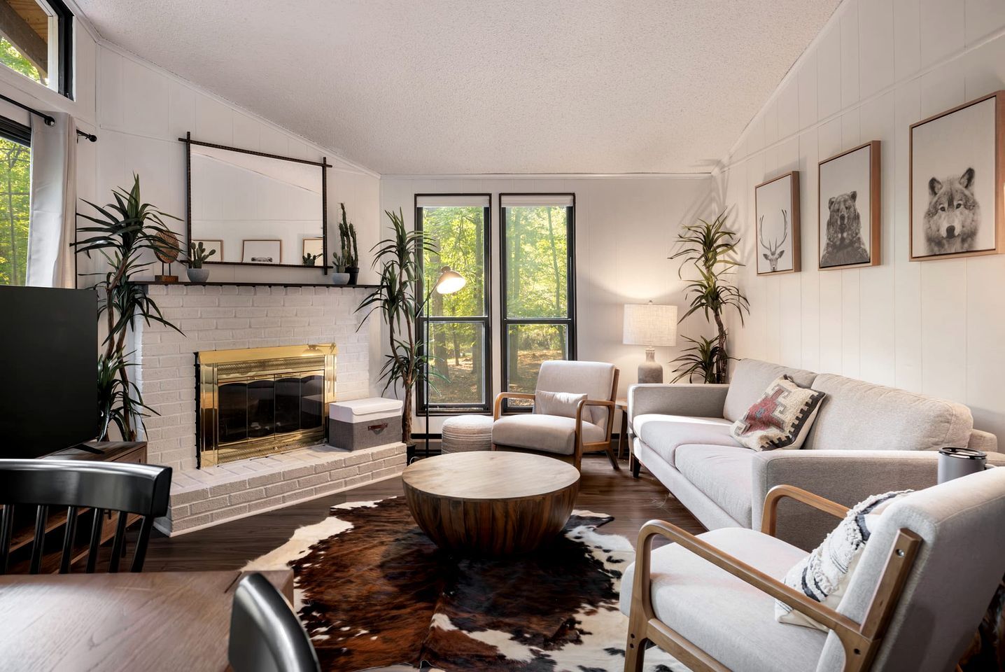 A modern living room with a fireplace, seating, and artwork.