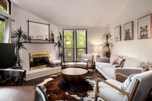A modern living room with a fireplace, seating, and artwork. - Incredible Cabin with Hot-tub and Barbecue in Hedgesville, West Virginia (Hedgesville)