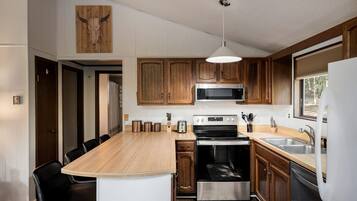 A modern kitchen with wooden cabinets, stainless steel appliances, and a central island.