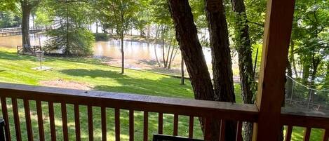 A wooden deck with a view of a lake and trees.