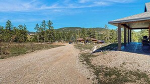 A gravel road leading to a building with a covered patio area. - Rost Place Round-Up - Dog-Friendly Cabin • Mtn Views & BBQ (Sturgis)