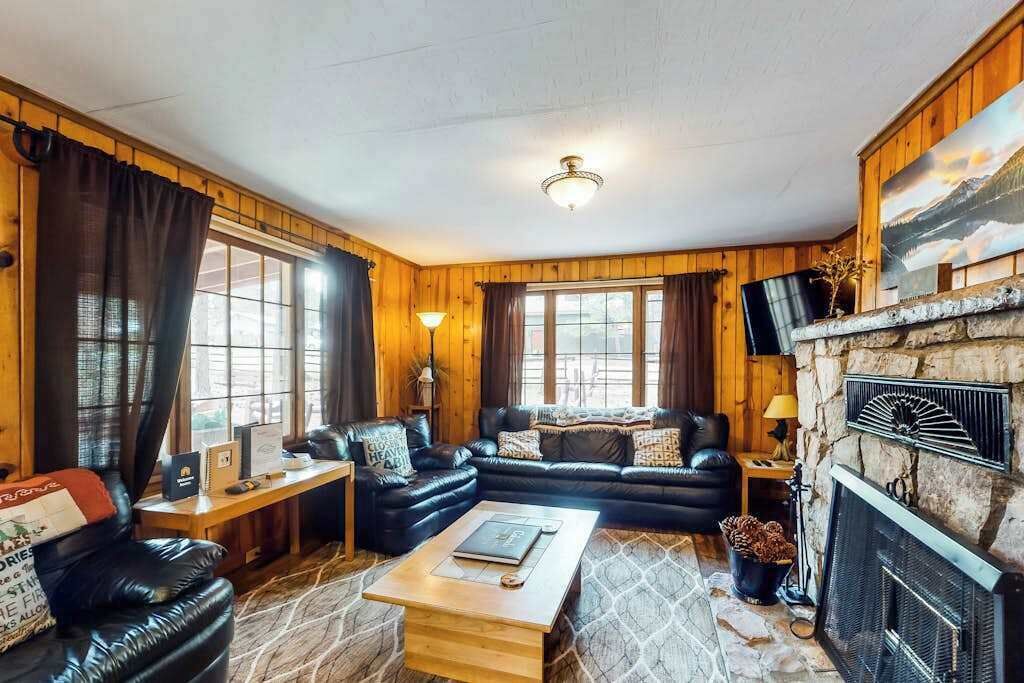 Un salon chaleureux avec une cheminée, un canapé en cuir et une table basse.