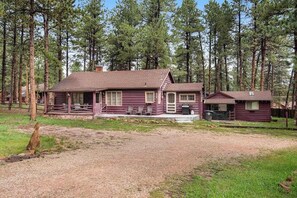 A cabin with a porch and a small attached structure, surrounded by a forest. - Big Bear Cabin - Dog-Friendly Cabin • Great Location (Woodland Park)